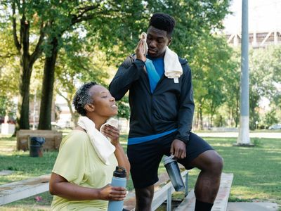 Water bottle and towel on a wooden bench.